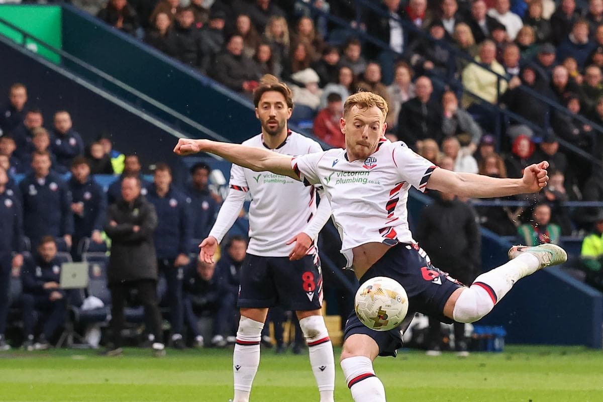 Player kicking ball during football match action