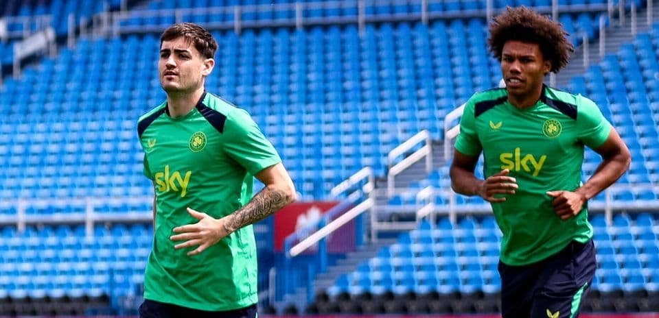 Two players jogging during training session on pitch