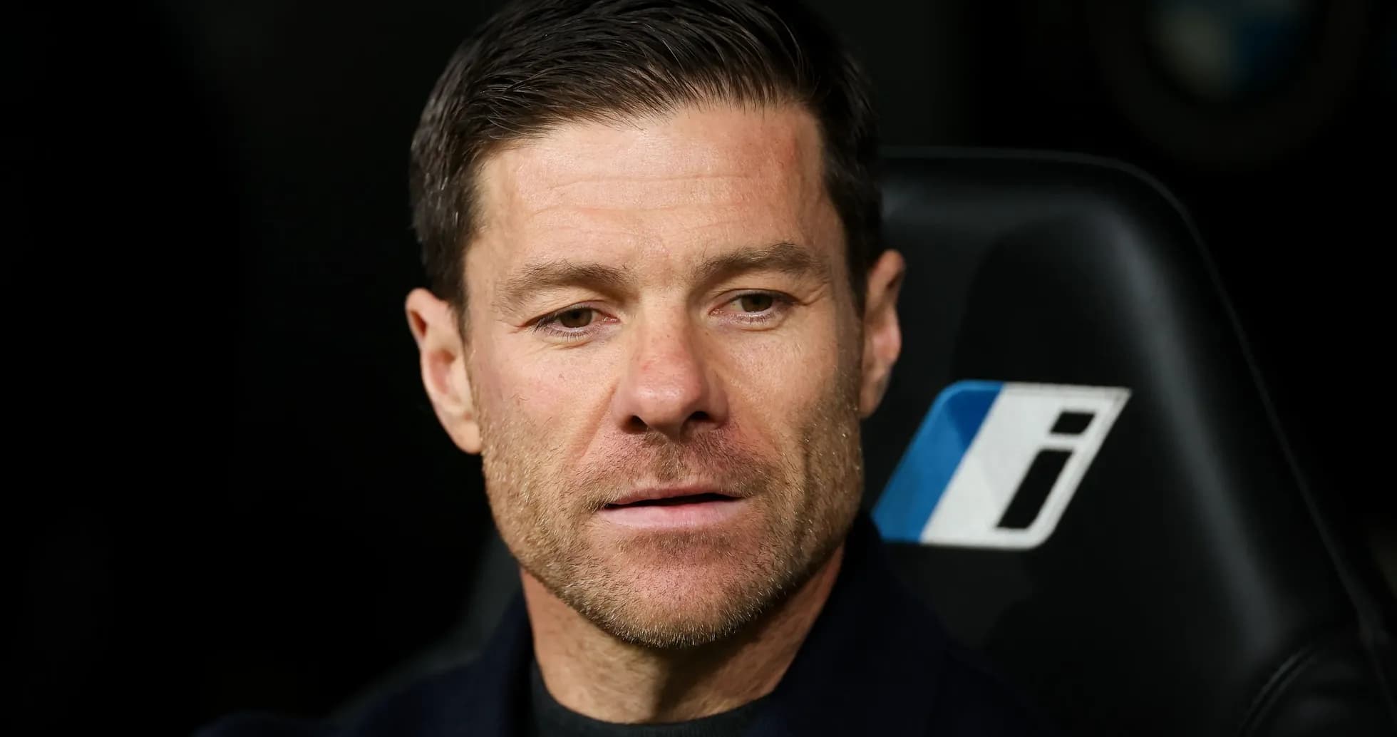 Coach seated on bench during match
