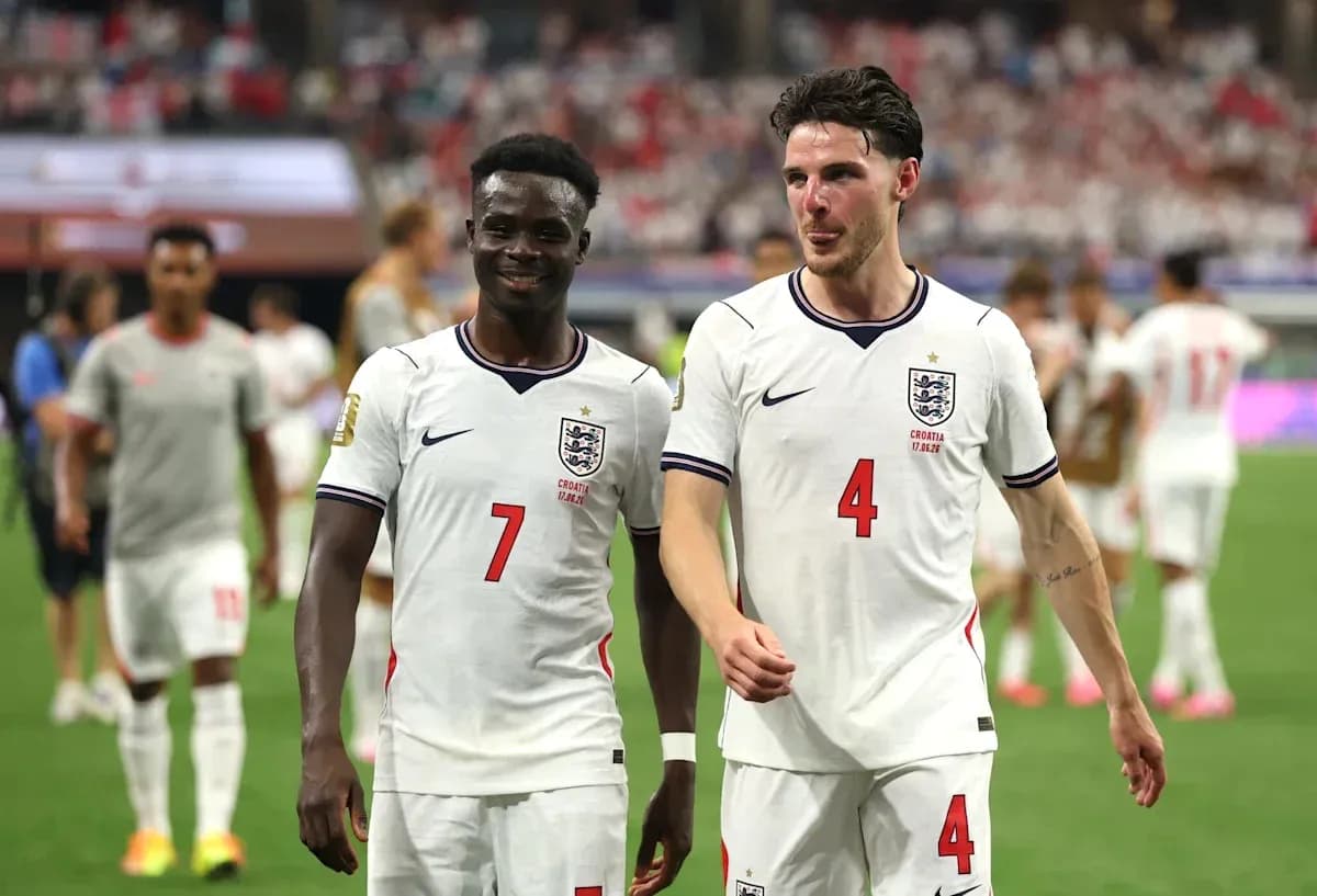 Two England players walking off the pitch after match
