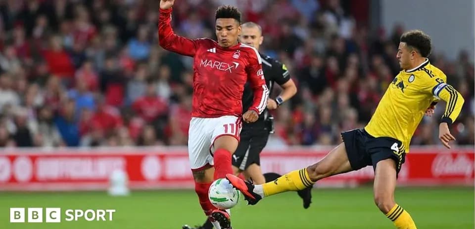 Player kicking ball while opponent challenges during match