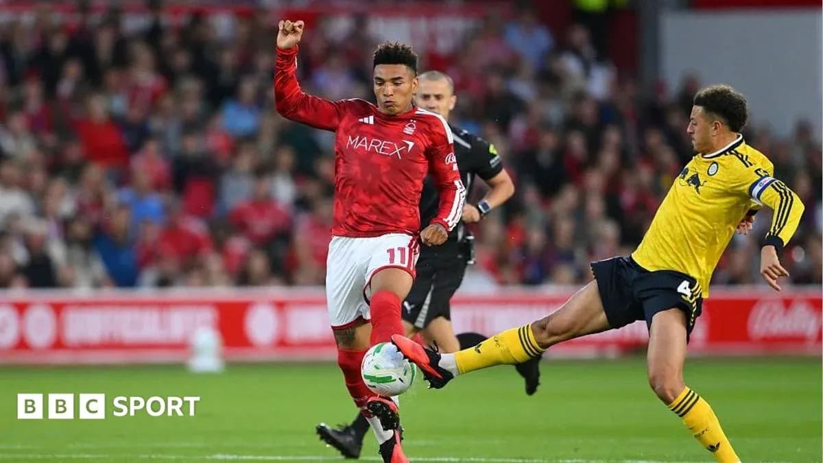 Player kicking ball while opponent challenges during match