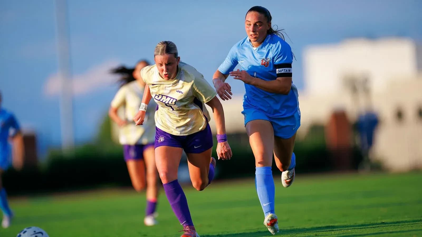 Two soccer players sprinting on the field