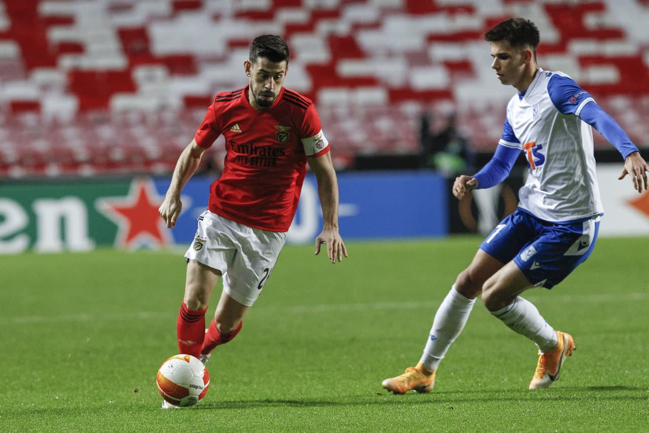 Benfica player dribbling against Lech Poznan opponent