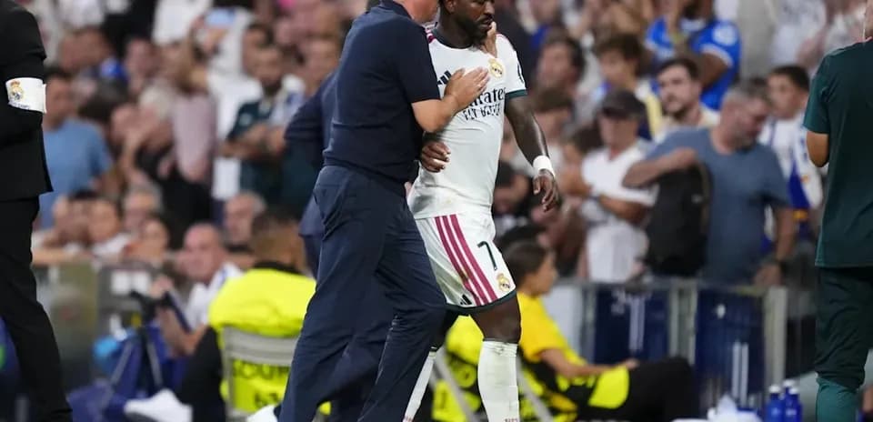 Coach guiding player off the field during match