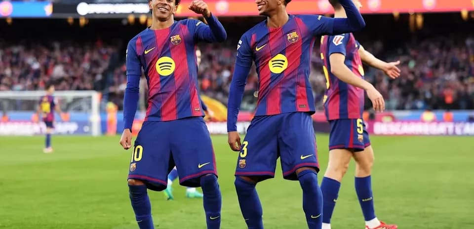 Two FC Barcelona players celebrating on the pitch