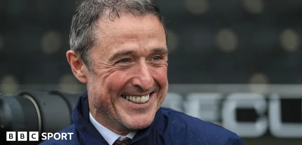 Smiling coach during post-match interview at stadium