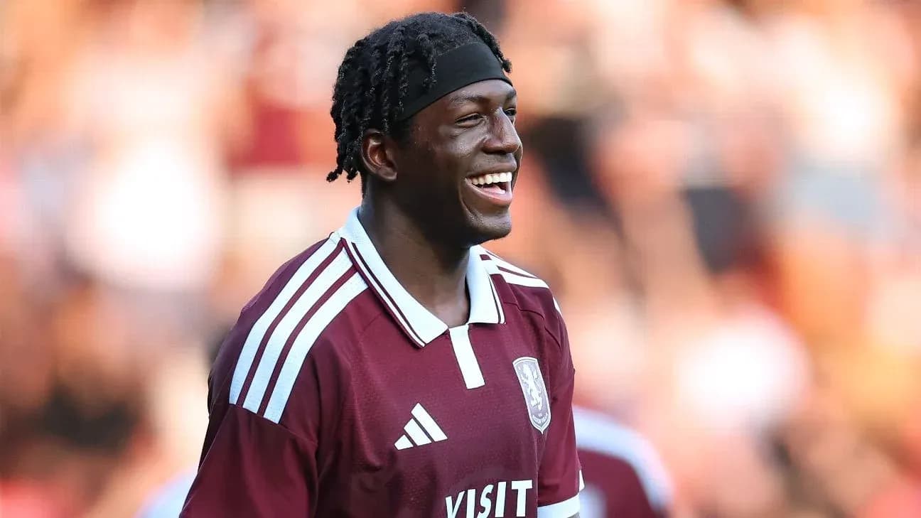 Player smiling in maroon team jersey on field