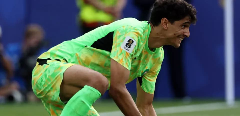 Goalkeeper in green kit preparing to catch ball
