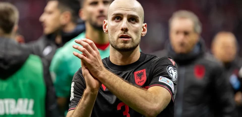 Player in black jersey applauding after match