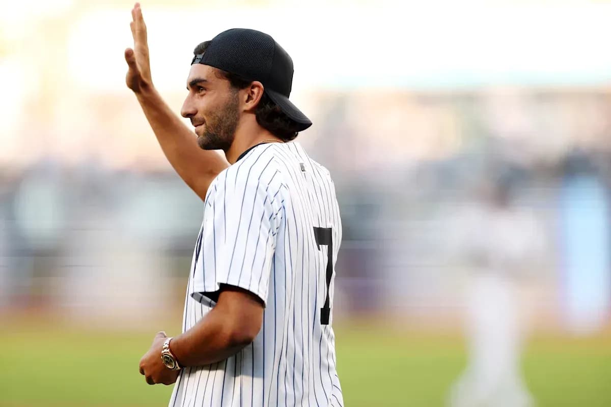 Person waving while wearing a baseball jersey