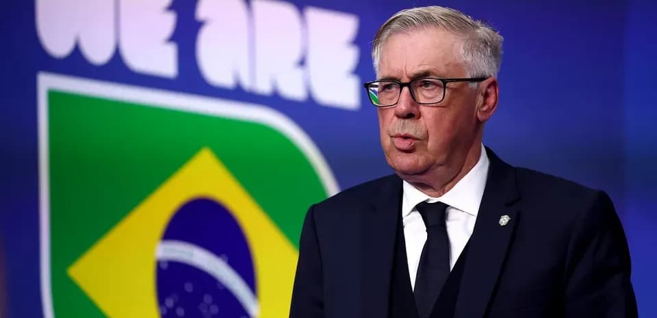 Manager speaking at press conference with Brazil flag backdrop