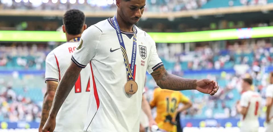 Player walking off field wearing bronze medal