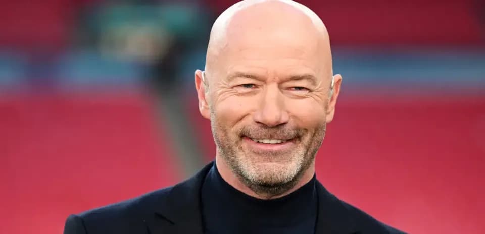 Smiling man in a black suit at stadium