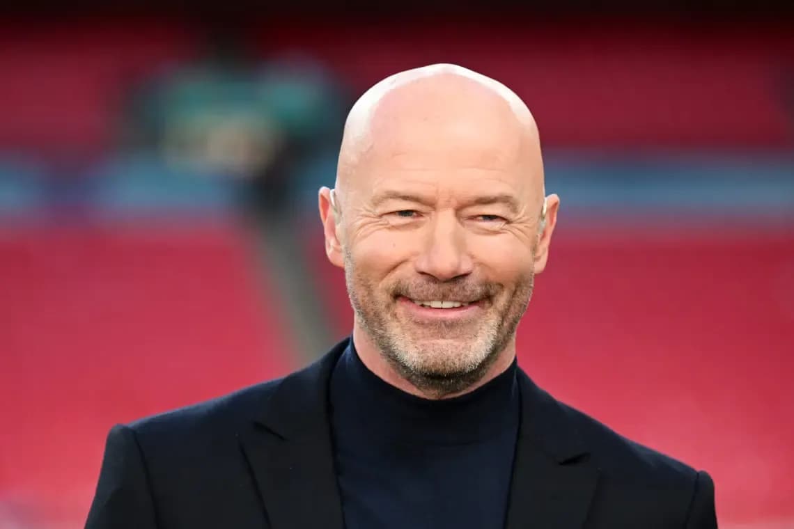 Smiling man in a black suit at stadium