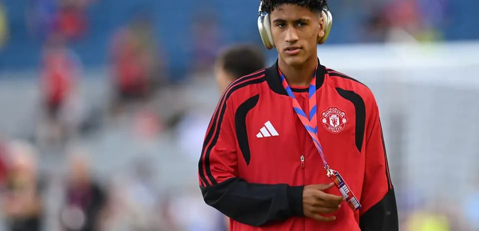 Player wearing headphones in Manchester United tracksuit