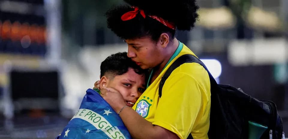 Two fans wrapped in Brazilian flag at event