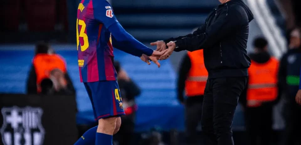 Player shaking hands with coach on the field
