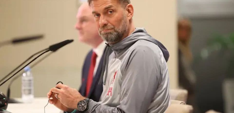 Manager at press conference with microphone and water bottle