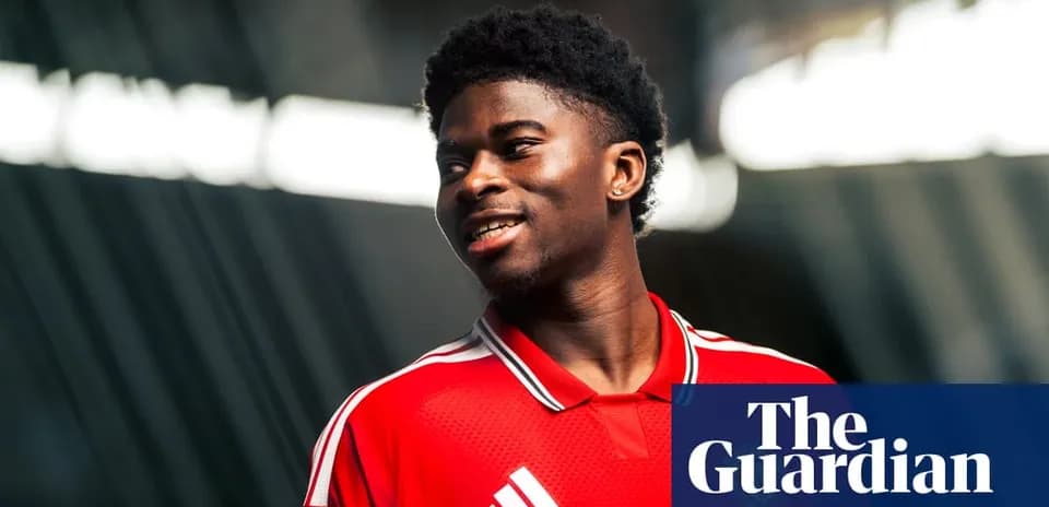 Player in red jersey smiling during photoshoot
