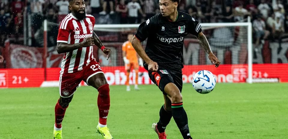 Player from NEC Nijmegen dribbling past Olympiakos defender