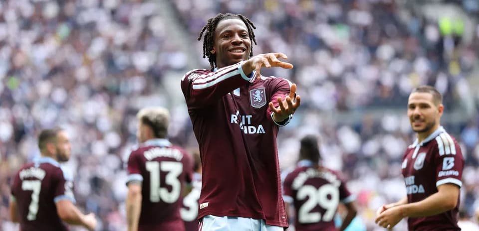 Aston Villa player celebrating with teammates on field