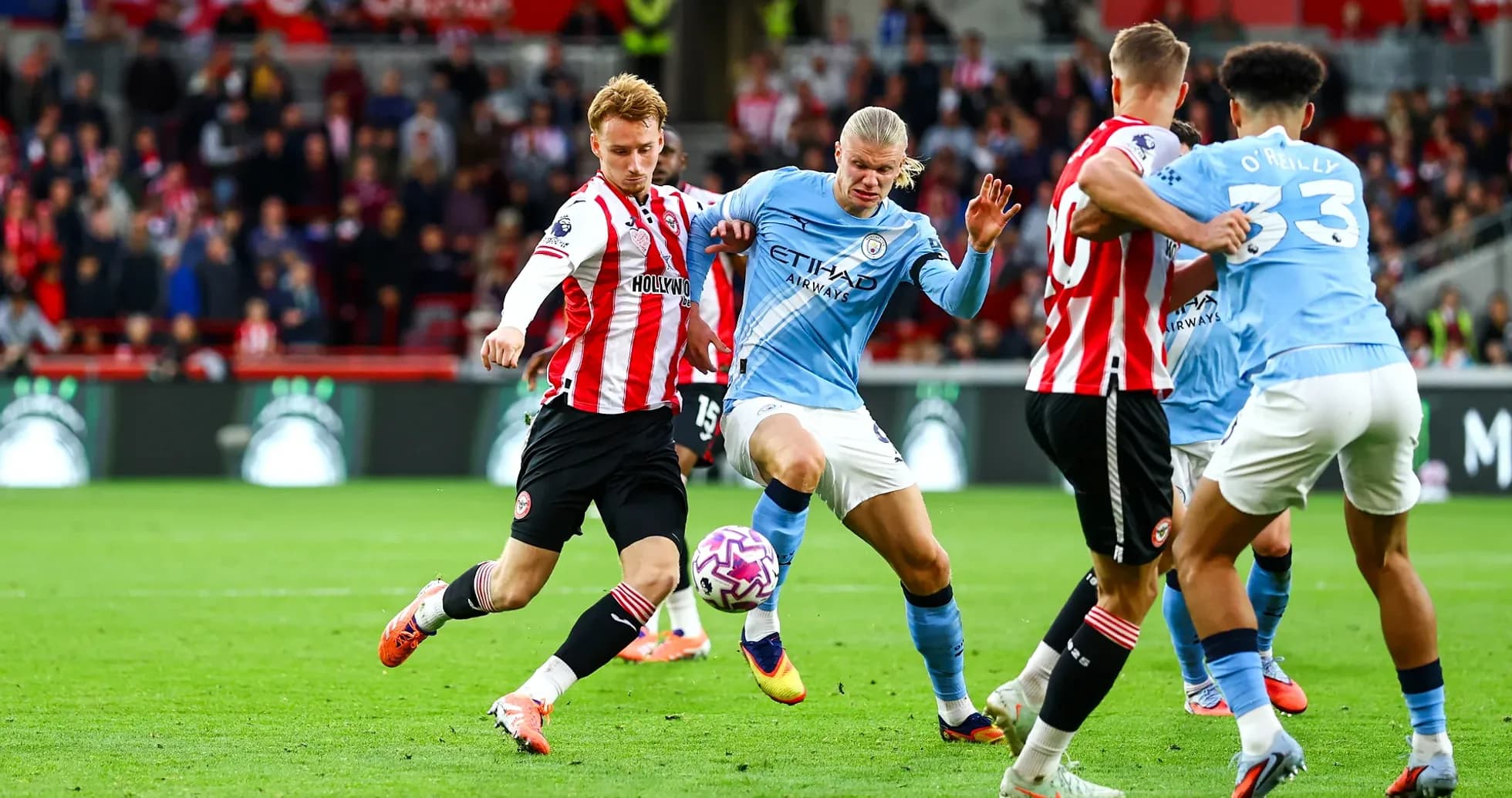 Manchester City players challenging Brentford opponents