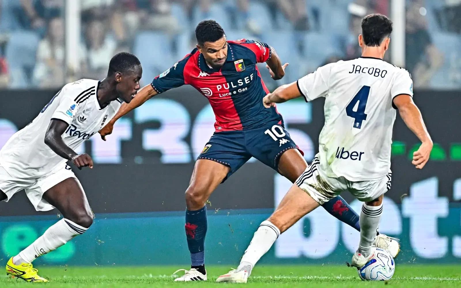 Genoa player dribbling past Como defenders