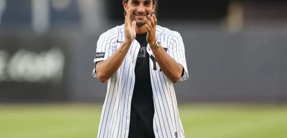 Person in Yankees jersey applauding on field