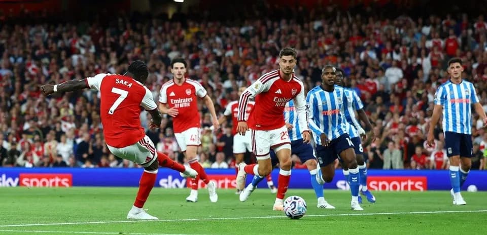Arsenal player Saka kicking the ball during match
