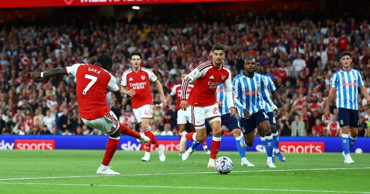 Arsenal player Saka kicking the ball during match