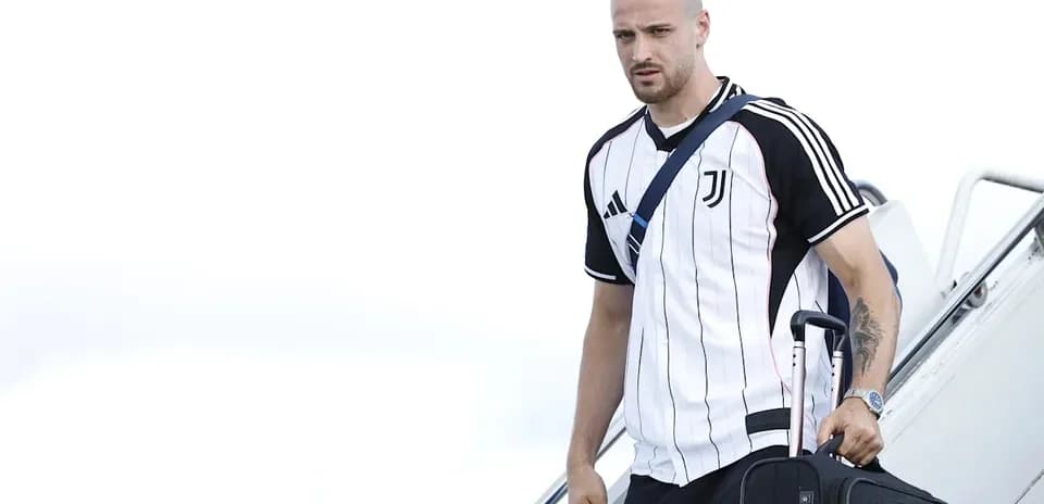 Player arriving with suitcase in Juventus jersey