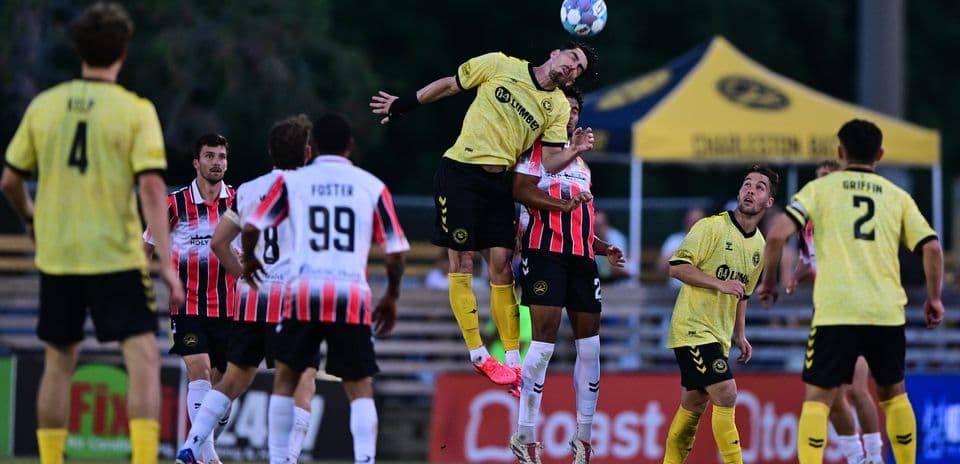 Charleston Battery player heading the ball during match