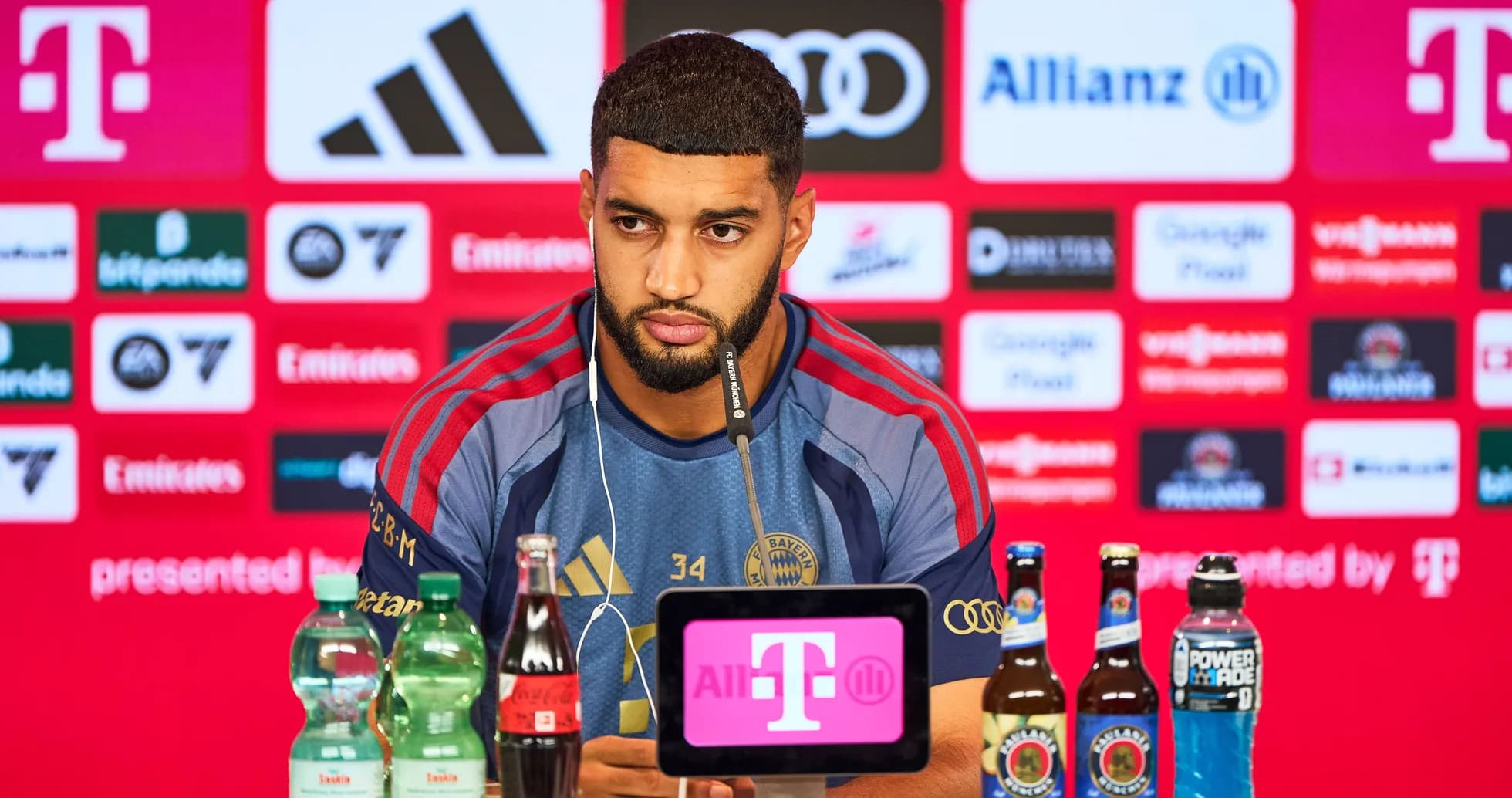 Player at press conference with sponsor logos behind