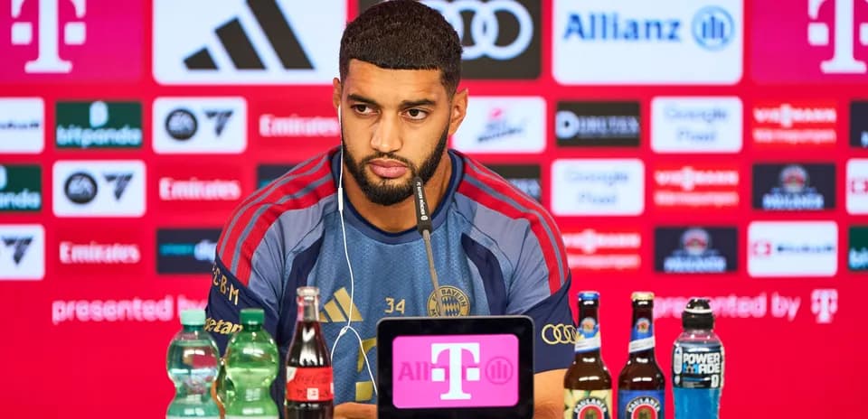 Player at press conference with sponsor logos behind