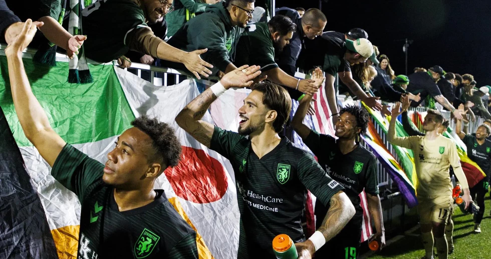 Lexington players celebrating with fans after match