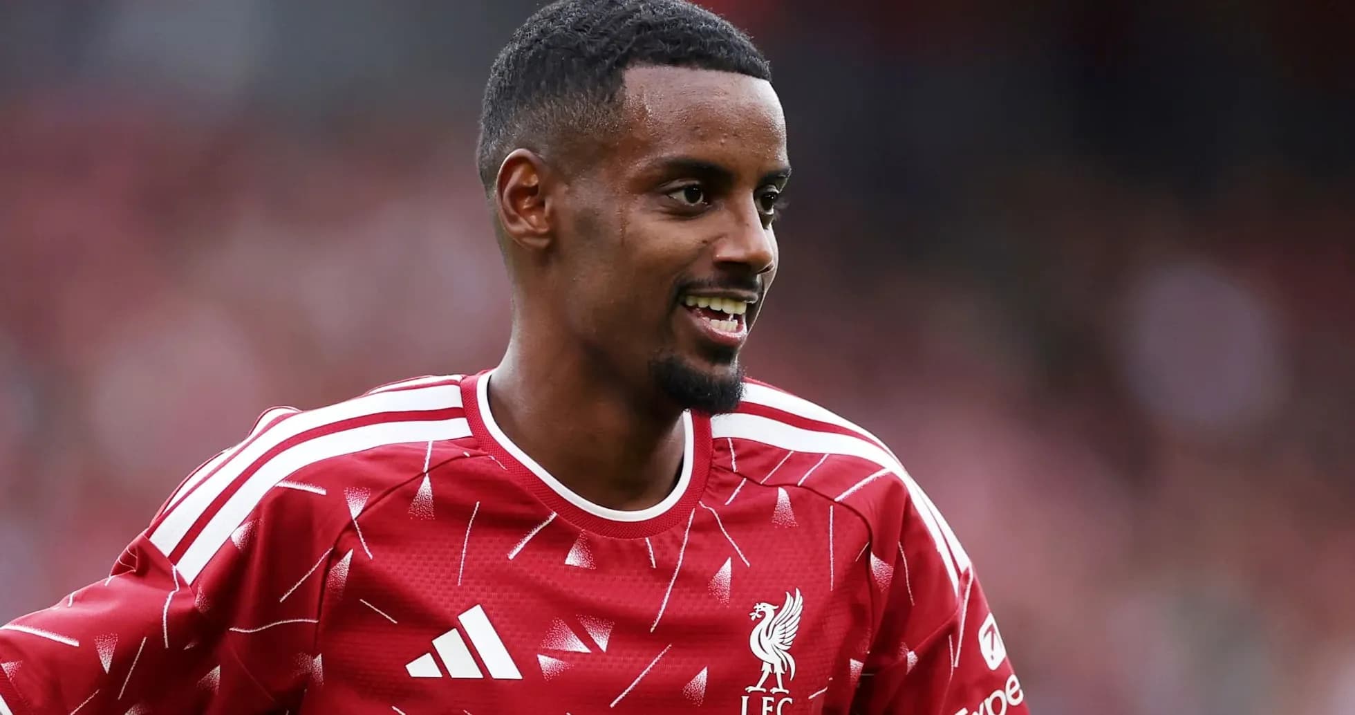 Player in Liverpool jersey smiling on the field
