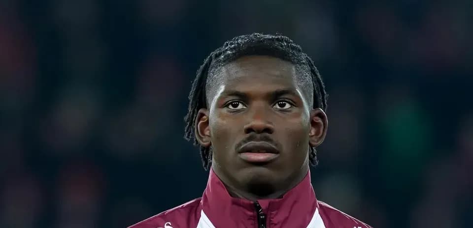 Player in maroon jacket during match preparation