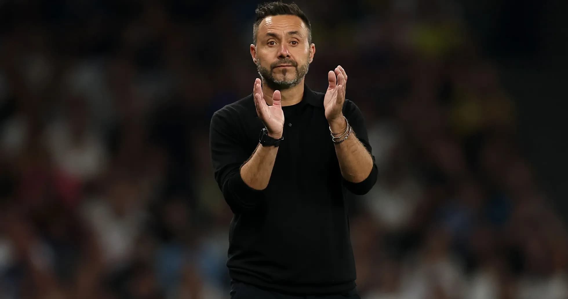 Coach clapping during a match on the sidelines