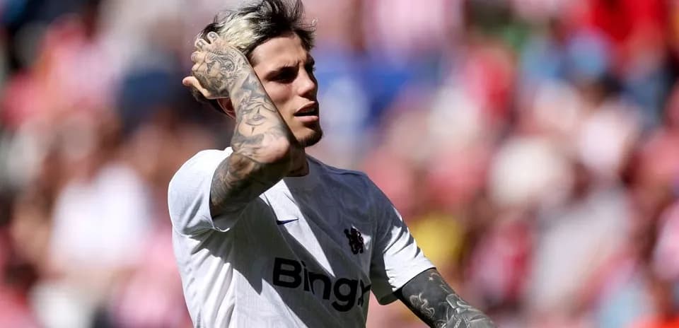 Player with tattoos adjusting hair during match