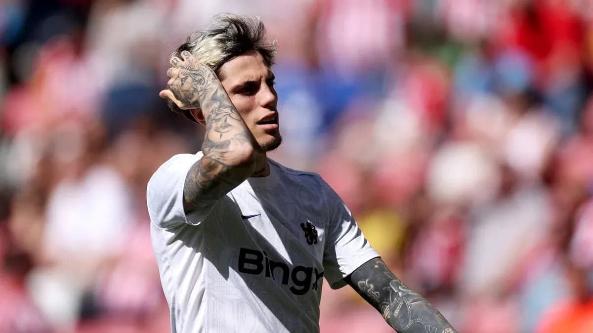 Player with tattoos adjusting hair during match