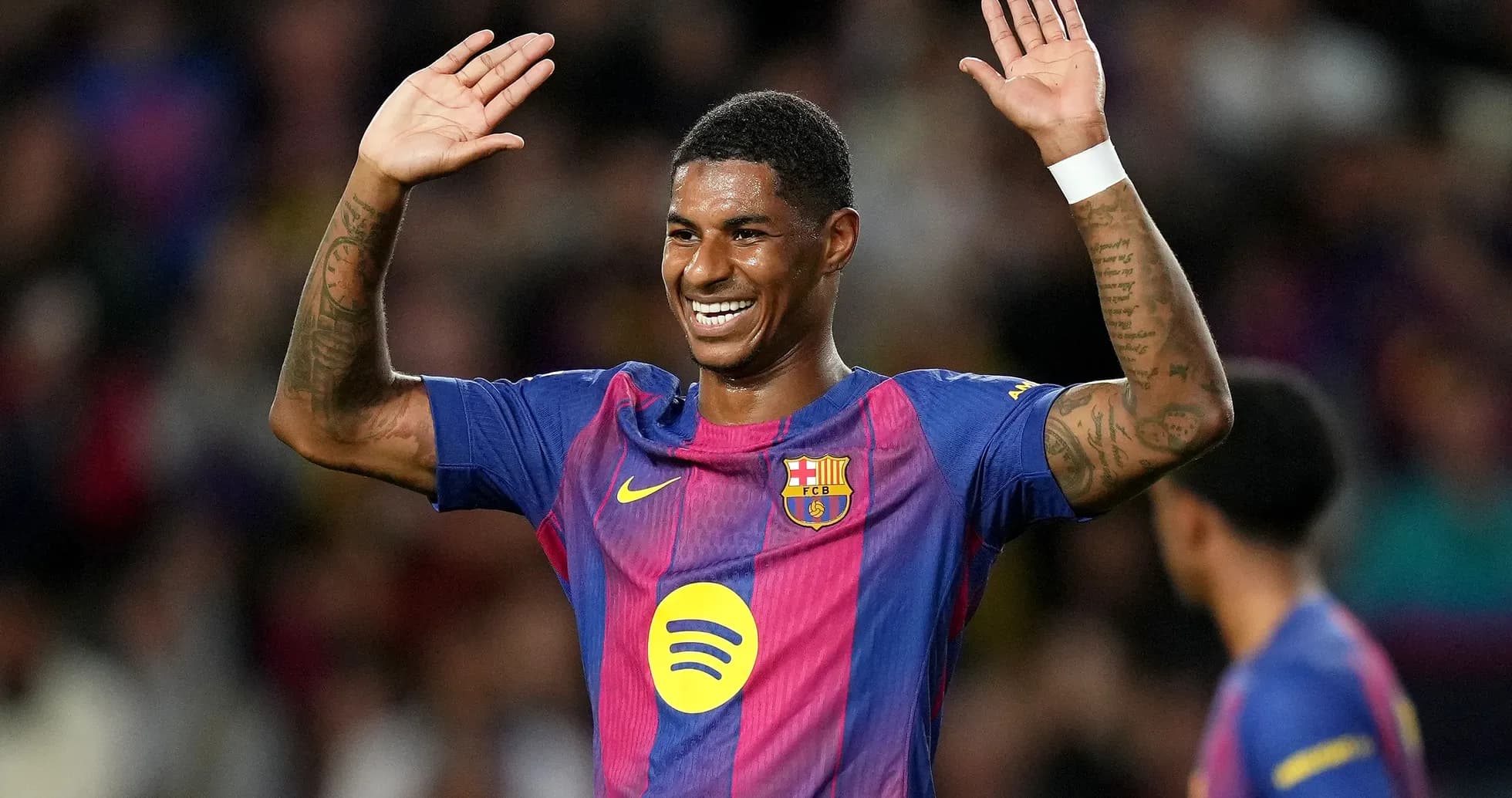 Barcelona player celebrating with raised hands on pitch