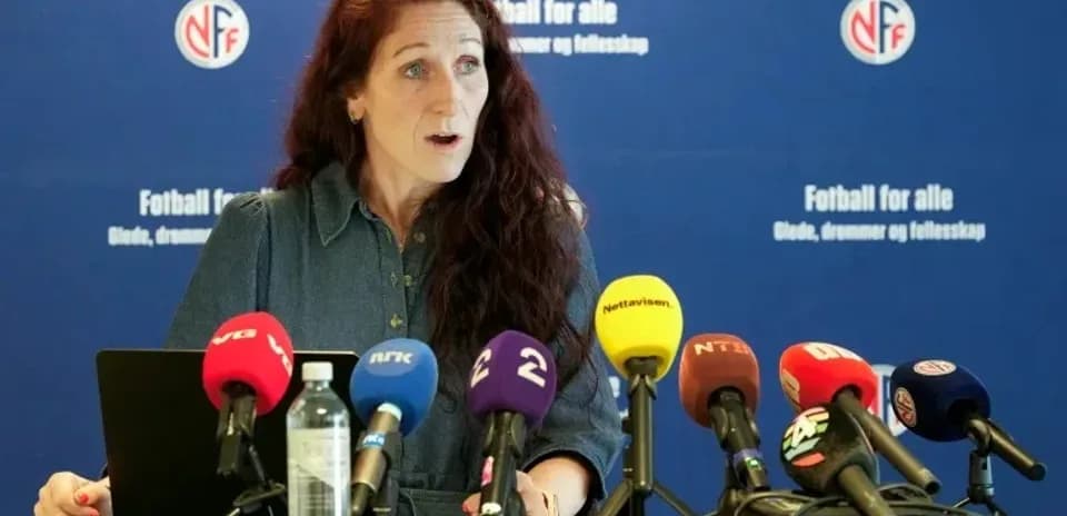 Woman speaking at press conference with microphones