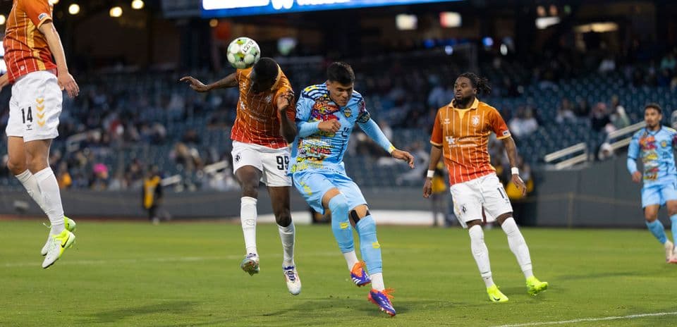 Players competing for the ball during USL match