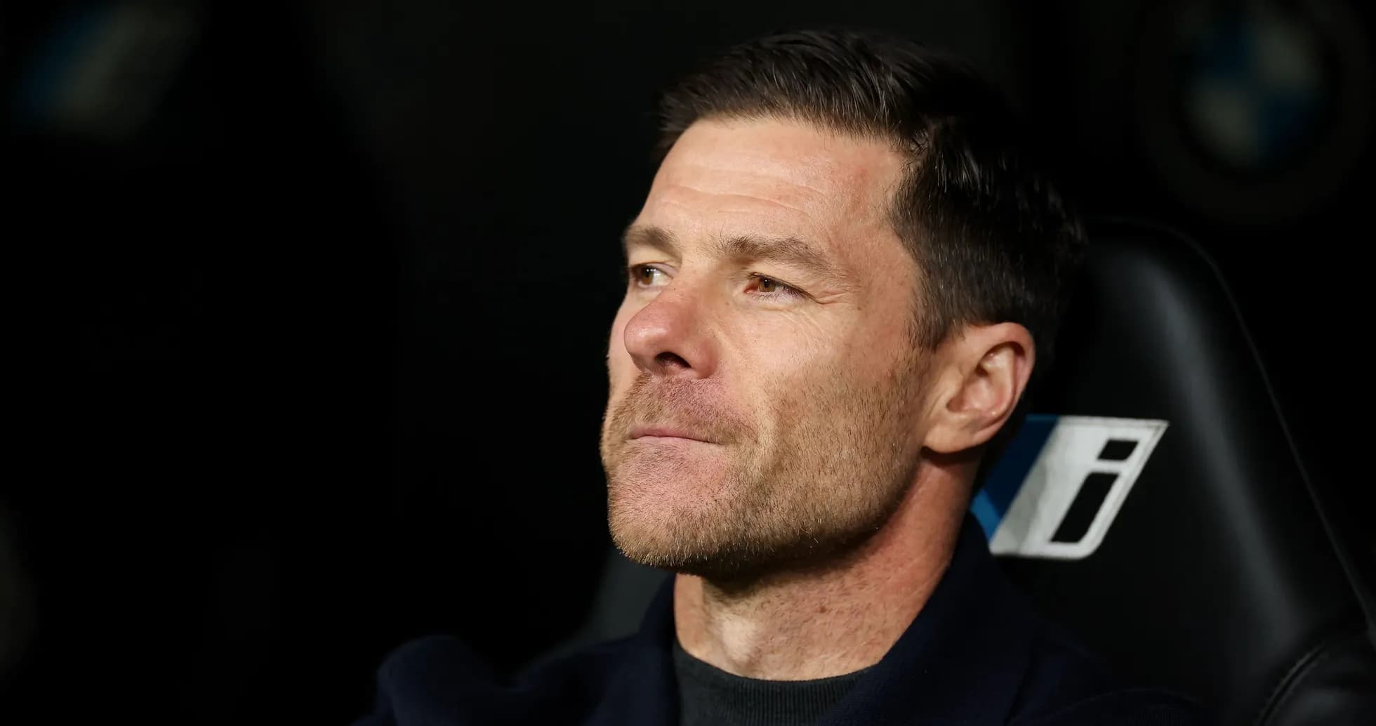 Coach seated on bench during a match