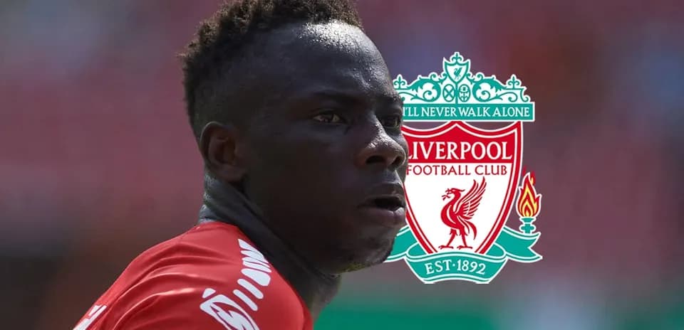 Player in Liverpool jersey with club logo backdrop