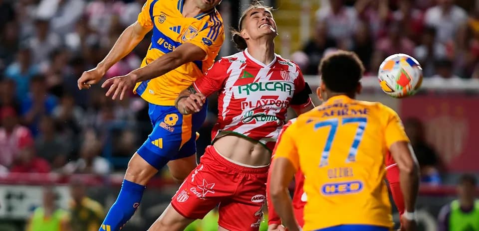 Players competing for the ball during Liga MX match