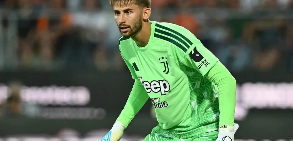 Goalkeeper in green jersey preparing for action