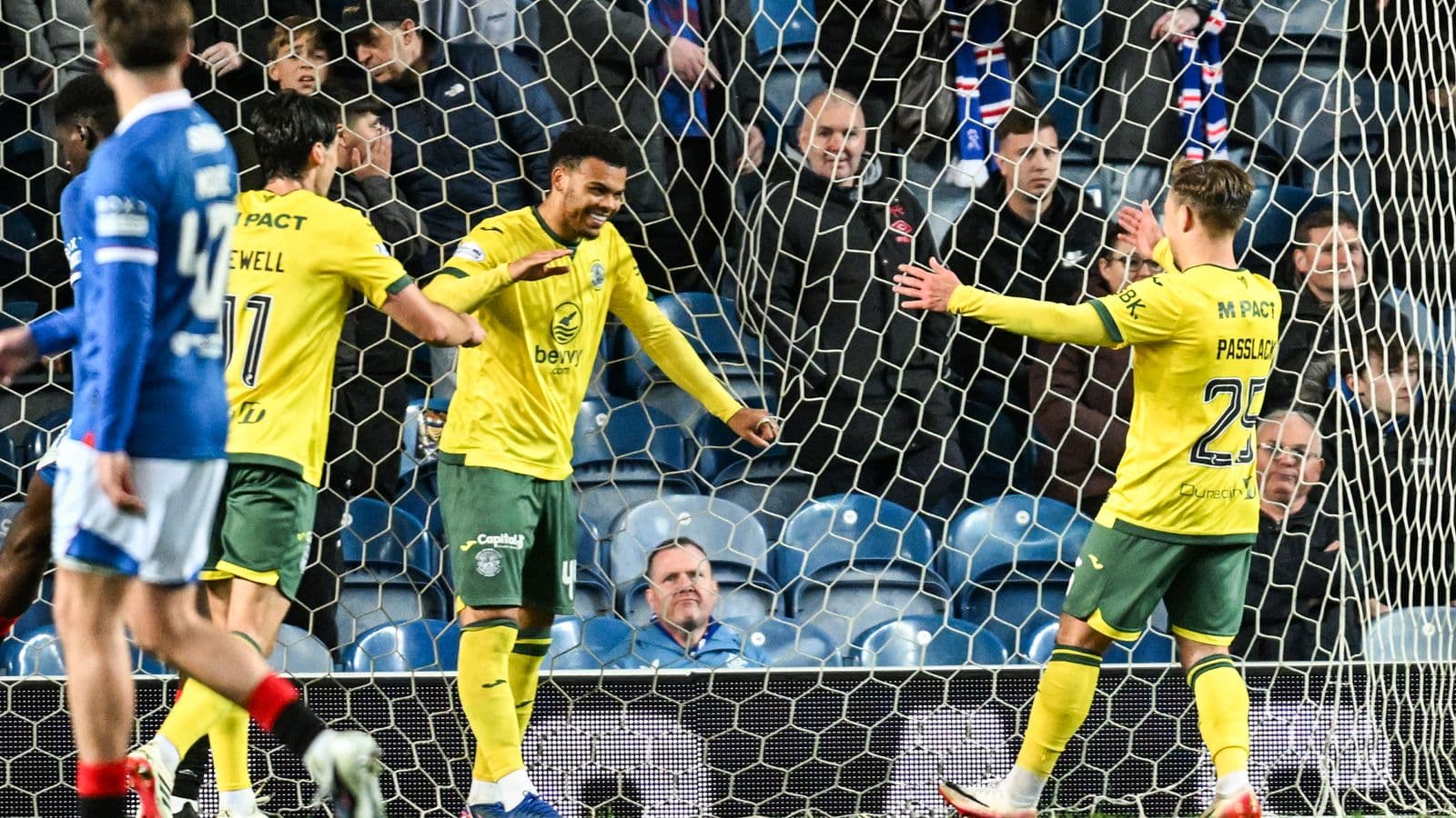 Players celebrating a goal in front of the net