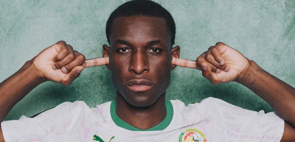 Football player in Senegal jersey covering ears